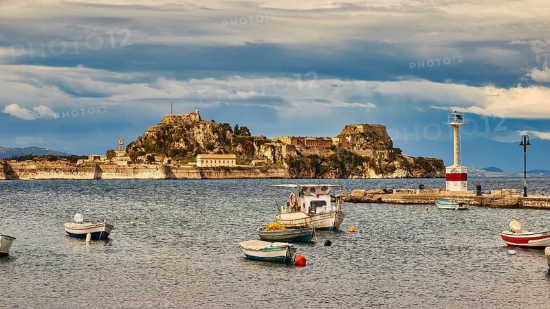 View of an island with fortress and small boats in the water under cloudy sky, UNESCO World Heritage Site, Old Town of Corfu, Corfu, Corfu, Ionian Islands, Greece