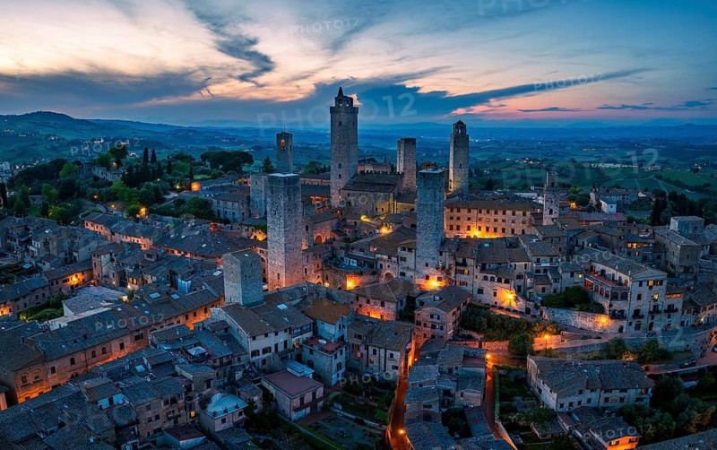 City view of San Gimignano at dusk, gender towers and medieval buildings, Tuscany, Italy