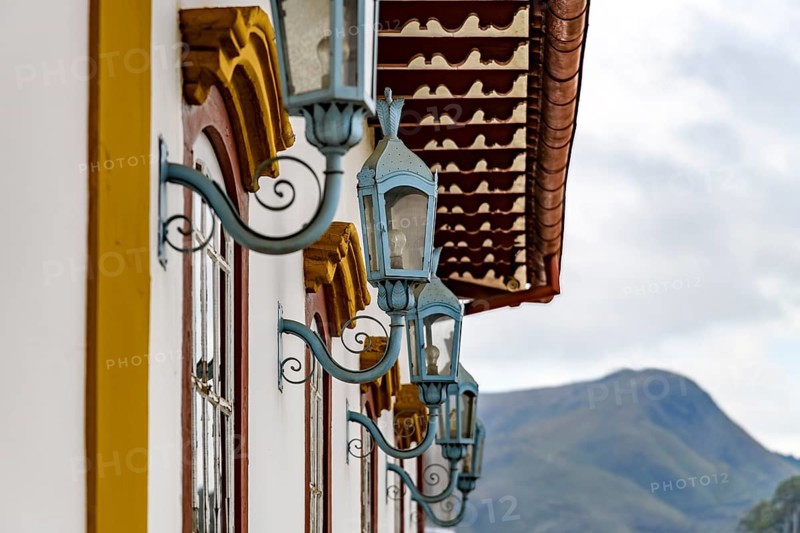 Several antique metal lanterns decorating the historical facade of a colonial-style house in the city of Ouro Preto, Ouro Preto, Minas Gerais, Brazil