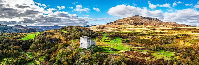 Autumn colours over Castell Dolwyddelan and Eryri Mountains from a drone, Snowdonia, Conwy County Borough, Wales, England, United Kingdom