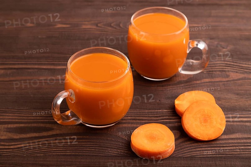 Two glasses with carrot juice, on wooden background. Diet, healthy eating concept. side view, close up, minimalism