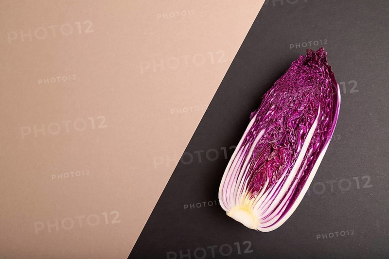 Purple Chinese cabbage on brown and black pastel paper background, top view, flat lay, copy space, minimalism