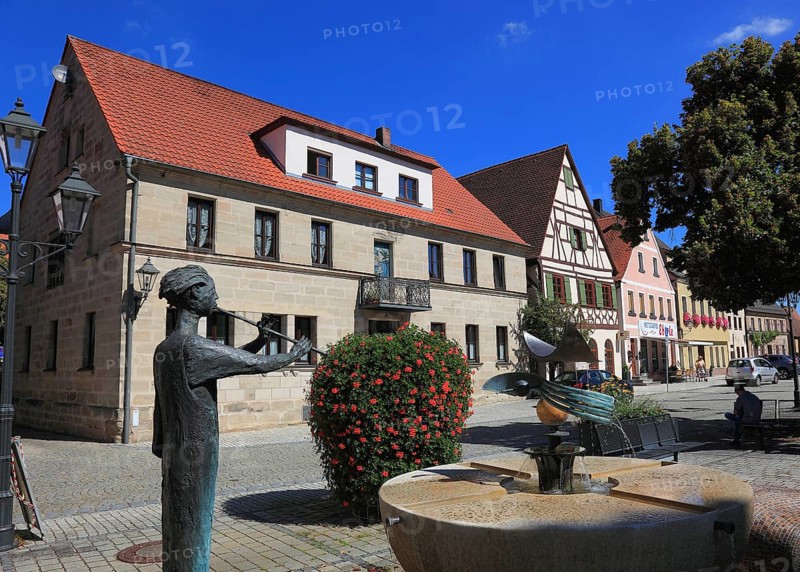 Half-timbered houses and fountain figure flute player, on Rathausplatz, city of Heideck in the district of Roth, Middle Franconia, Bavaria, Germany