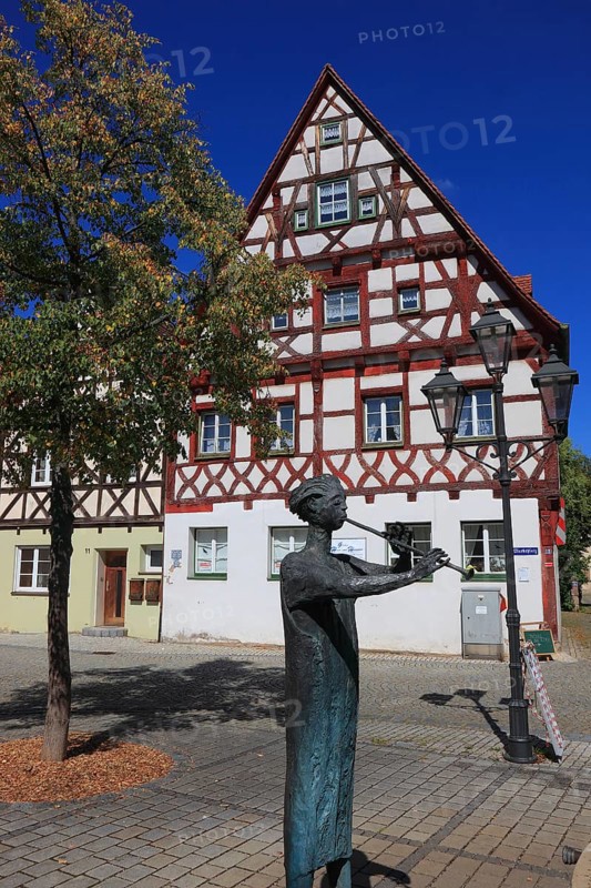 Half-timbered houses and fountain figure flute player, on Rathausplatz, city of Heideck in the district of Roth, Middle Franconia, Bavaria, Germany