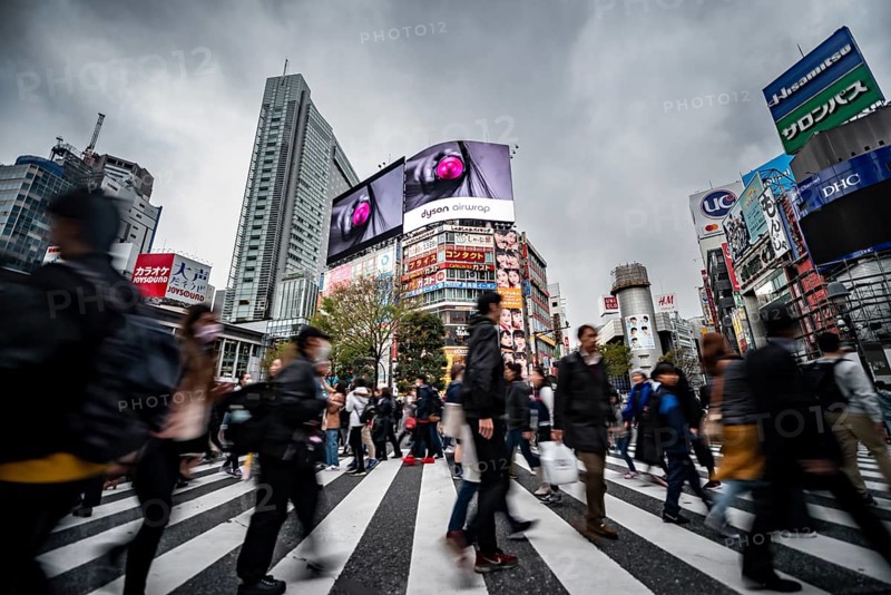 Crowd crossing zebra crossing on a large intersection, motion blur, back modern houses with colorful neon signs, long exposure, Shibuya Crossing, Shibuya, Tokyo, Japan