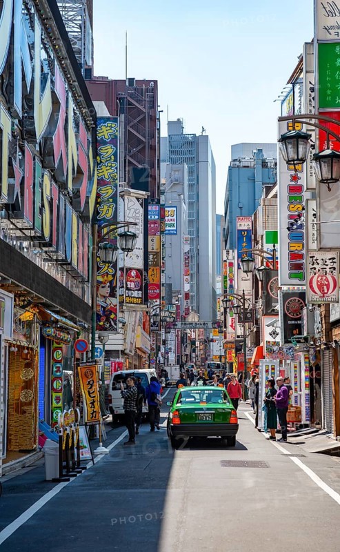 Street scene, lots of colorful signs of shops, restaurants and bars in a street, Shinjuku City, Tokyo, Japan