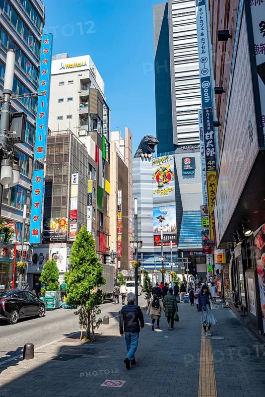 Street scene with skyscrapers, figure Godzilla head on a skyscraper, Shinjuku City, Tokyo, Japan