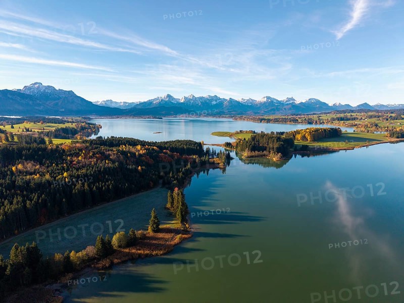 Clear reflections of a quiet lake surrounded by forests and mountains in autumn, Illasbergsee, Forggensee, near Roßhaupten, Ostallgäu, Allgäu, Swabia, Bavaria, Germany
