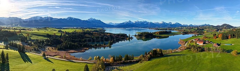 Panoramic view of a green landscape with lake and mountains under a clear sky, Illasbergsee, Forggensee, near Roßhaupten, Ostallgäu, Allgäu, Swabia, Bavaria, Germany