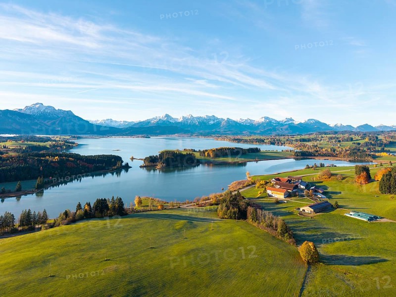 Extensive landscape with mountains in the background, a lake and green meadows in the foreground, Illasbergsee, Forggensee, near Roßhaupten, Ostallgäu, Allgäu, Swabia, Bavaria, Germany