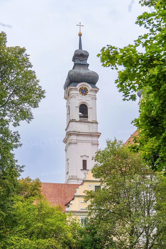 A tall church tower rises above the treetops, dominates the cloudy sky, ZFP Zwiefalten, Reutlingen district, Germany