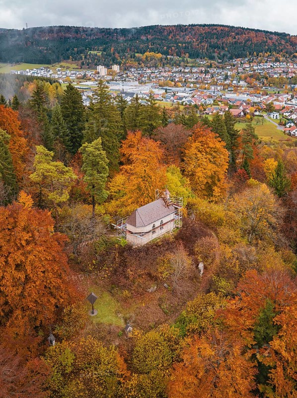 Historic pavilion surrounded by colorful autumn vegetation with a view of the city and hills under cloudy sky, Wehingen, Tuttlingen district, Germany