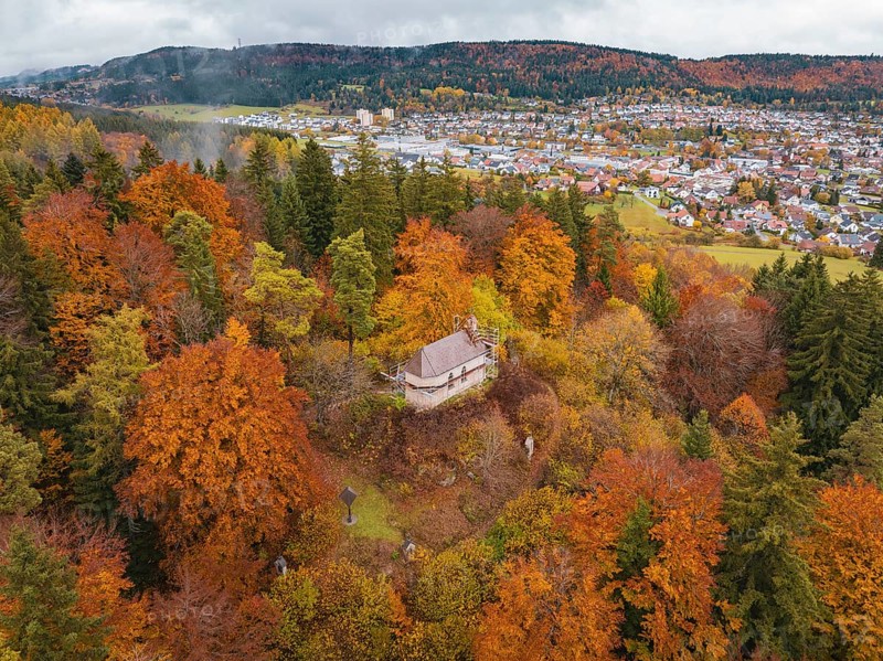 Pavilion in the middle of a colorful autumn forest with a view of a city in the distance under a cloudy sky, Wehingen, Tuttlingen district, Germany