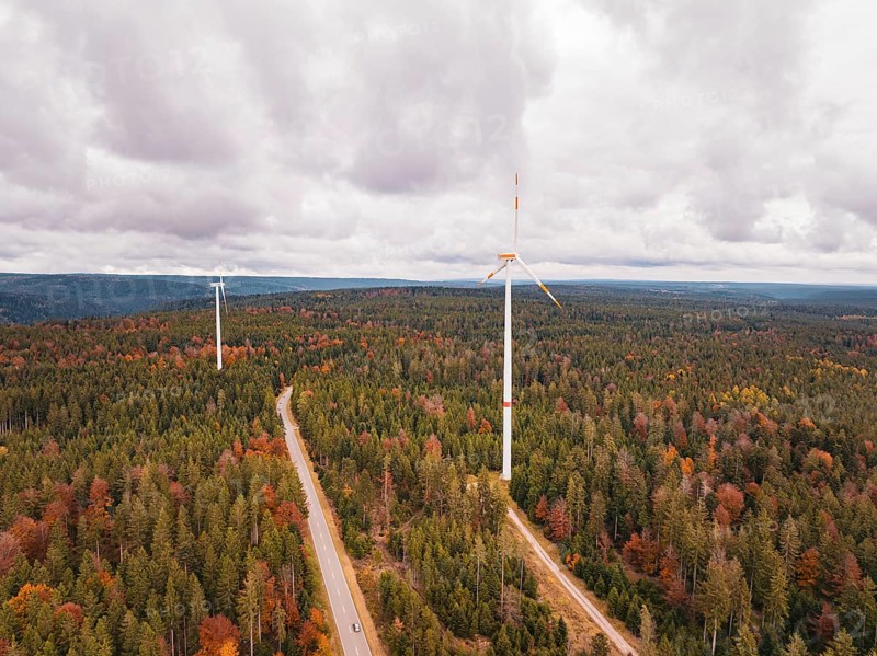 Wind turbines in autumn forest surrounded by clouds and roads, Simmersfeld wind farm, Germany