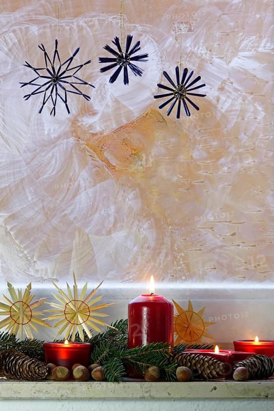 Christmassy decorated iced window, candle light, straw stars, Germany