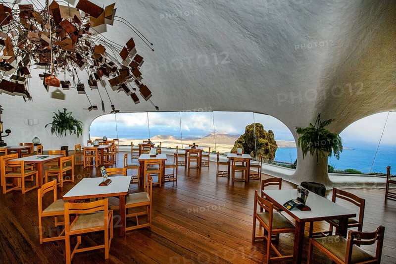 Interior of café with panoramic window in building designed by Cesar Manrique with the collaboration of Jesús Soto and architect Eduardo Caceres without right angles corners on viewpoint tourist attraction El Mirador del Río on the summit of the 474 meter high Risco de Famara in Famaramassiv with panoramic view of the Chinijo Archipelago, La Graciosa island, Lanzarote, Canary Islands, Canary Islands, Spain