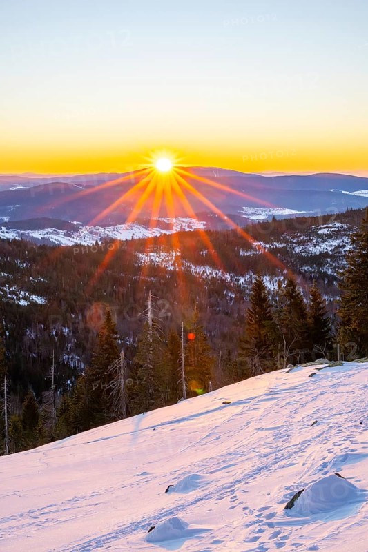 Sunrise over the hills of czech republic from Mount Lusen wth the view over the hills of the bavarian forest in winter, Bavaria, Germany