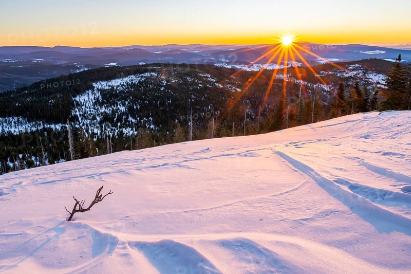 Sunrise over the hills of czech republic from Mount Lusen wth the view over the hills of the bavarian forest in winter, Bavaria, Germany