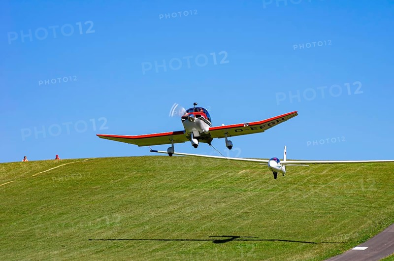 A Robin DR 400/200R Remorqueur light aircraft, registration D-EFGH, tows a glider during a flight demonstration as part of an air show on Rossfeld in Metzingen-Glems, Baden-Württemberg, Germany, for editorial use only