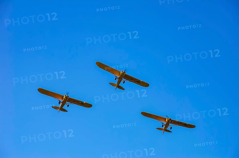 Three Piper PA-18 Super Cub aircraft from the Bravo Lima Formation flying group in formation flight during a flight demonstration at the Rossfeld Air Sports Club Air Sports Association on Rossfeld in Metzingen-Glems, Baden-Württemberg, Germany, for editorial use only