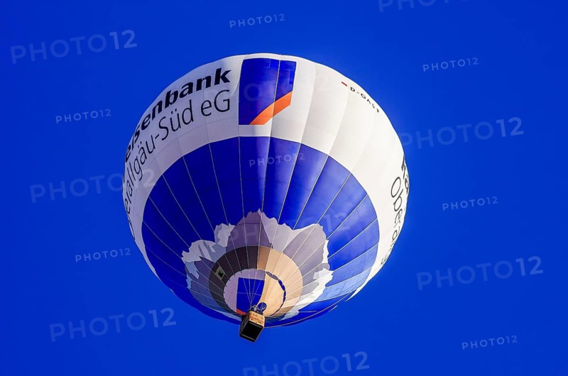 A hot air balloon, registration D-OASF, rises into the air as part of an air show at the Fliegerbergfest of the Rossfeld Luftsportverein in Metzingen-Glems, Baden-Württemberg, Germany, for editorial use only