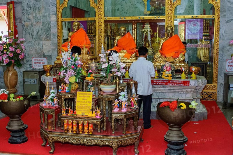 Buddhist believers Buddhists pray making offerings to statues of Buddhist monks covered with gold leaf at Wat Chalong Monastery, Wat Chaithararam, Phuket Island, Phuket Province, Thailand