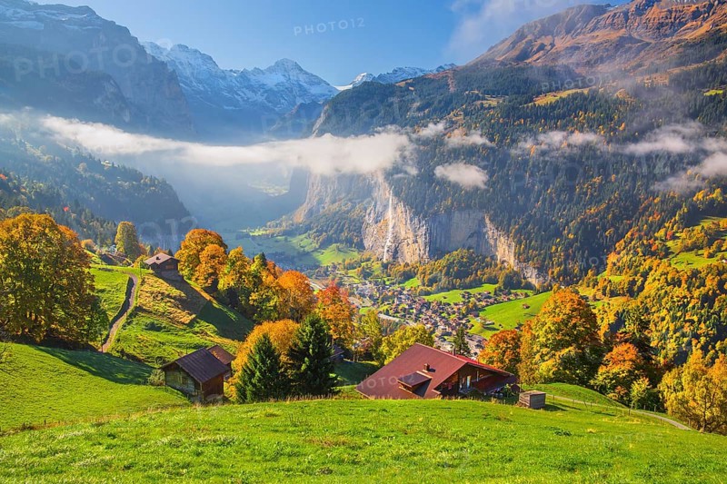 View from the village of the Lauterbrunnen Valley with Staubbach waterfall in autumn with morning fog, Wengen, Bernese Oberland, Canton of Bern, Switzerland