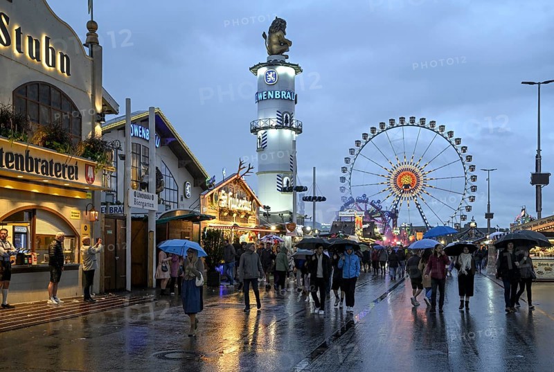 Oktoberfest visitors with umbrellas, rainy meadows, Löwenbräuturm, Ferris wheel, Munich, Bavaria, Germany