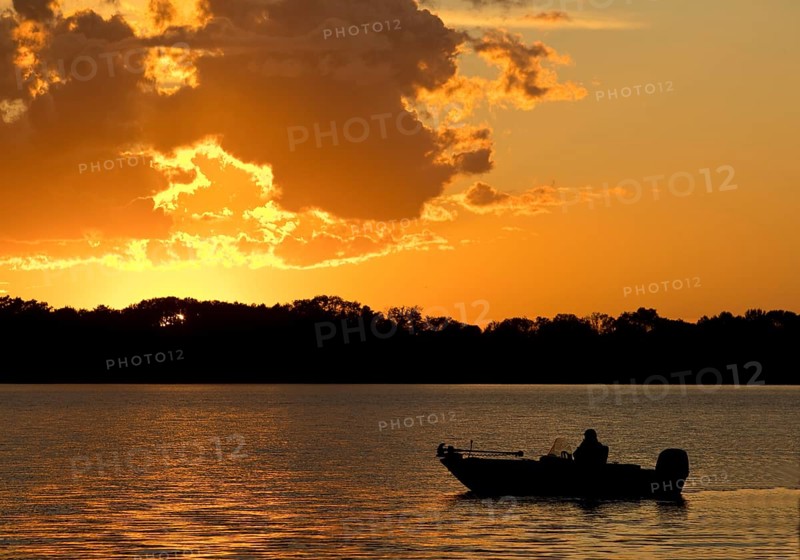 A boat on Lake Gudelack at sunset, Lindow (Mark), Stechlin-Ruppiner Land nature park Park, Brandenburg, Germany