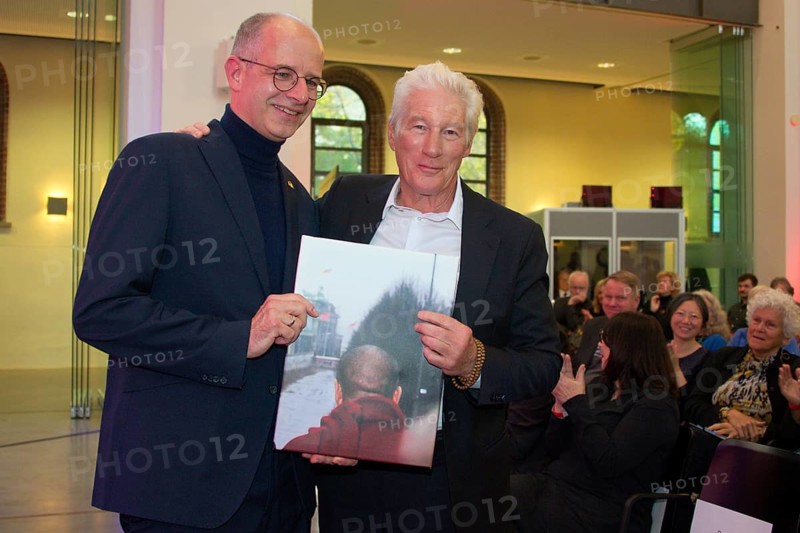 Richard Gere (International Chairman of the International Campaign for Tibet) receives a personal gift from Michael Brand (MdB) (photo of the Dalai Llama at the Brandenburg Gate in 1989), at the presentation of the Snow Lion Human Rights Prize, Umweltforum Berlin, 25.10.2025