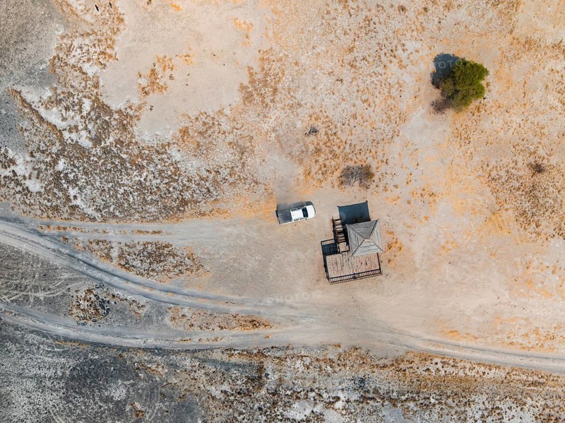 Aerial view, top-down view, off-road car driving on a salt pan, arid landscape, Botswana