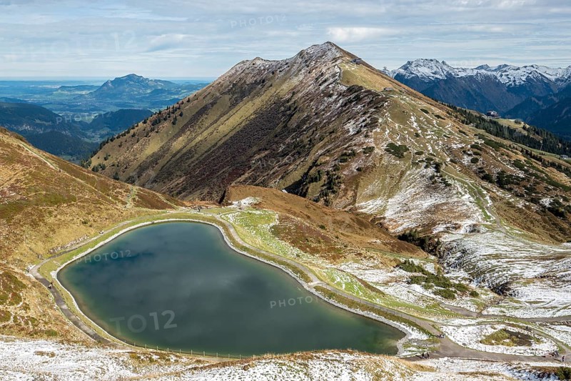 Reservoir, Kanzelwand snow-making pond, behind Fellhorn and mountains of the Allgäu Alps, Vorarlberg, Austria