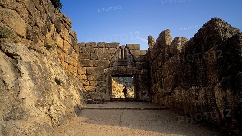 Single person standing in a huge stone gate, lion gate, Mycenae, archaeological site, UNESCO World Heritage Site, Mycenae, Mycenae, important city in pre-classical times, Peloponnese, peninsula, Greece