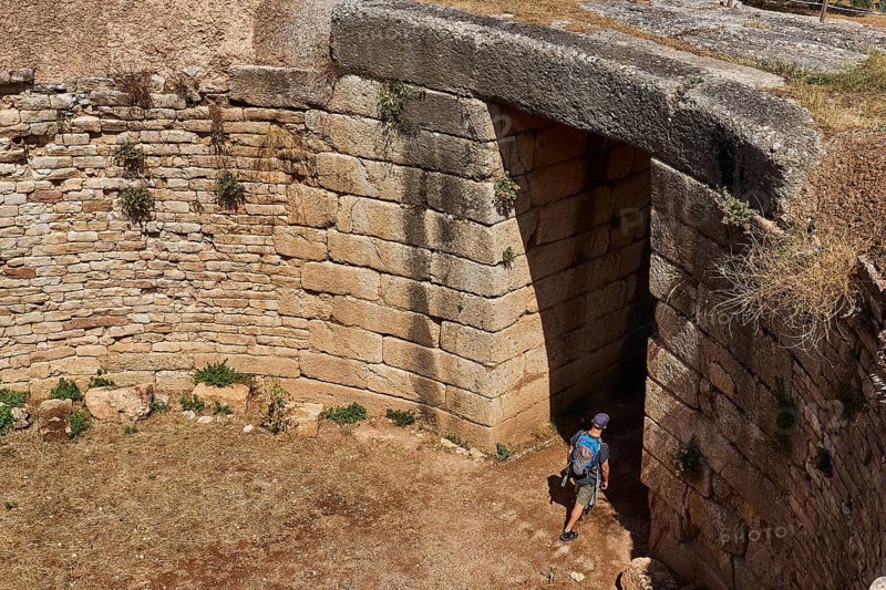 Visitor walks through huge stone gate, Mycenaean domed tomb, archaeological site, UNESCO World Heritage Site, Mycenae, Mycenae, important city in pre-classical times, Peloponnese, peninsula, Greece