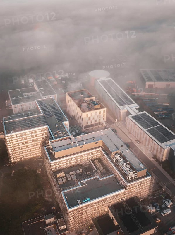 Urban industrial area seen from above in fog and dawn, new hospital health campus building, Calw, Germany