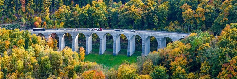Todsburg bridge on the A8 motorway near Mühlhausen. Alpine climb to the Swabian Jura in autumn. The roadways are separated, the Alben descent takes place over a parallel valley. Drone photo. Mühlhausen im Täle, Baden-Württemberg, Germany