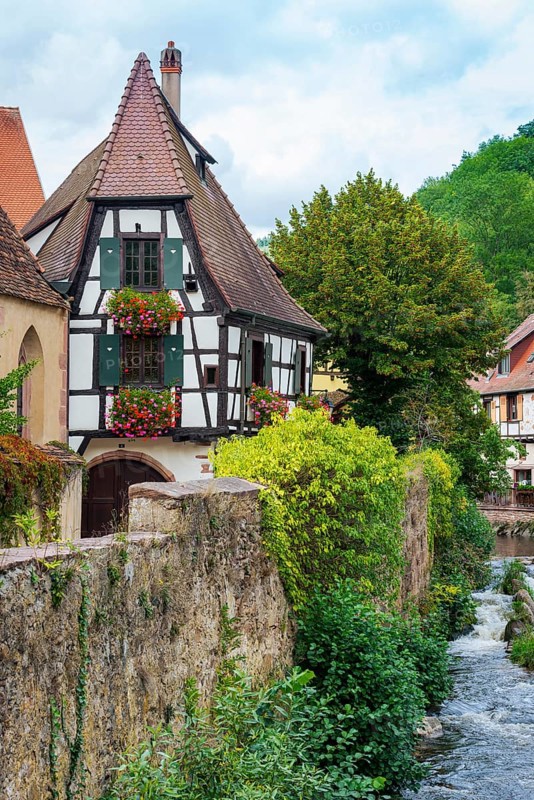 Picturesque Kaysersberg with half-timbered houses on the Weiss river in the old town centre