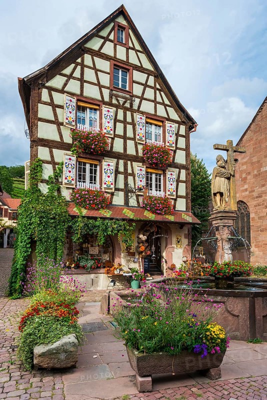 Emperor Constantin fountain in front of a half-timbered house in Kaysersberg
