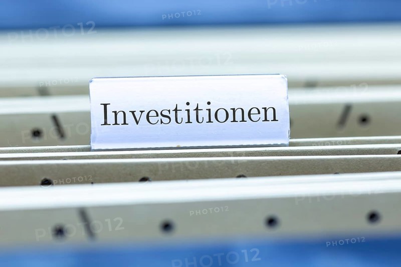 (Photomontage) Sign with the inscription INVESTMENTS on a suspension file folder