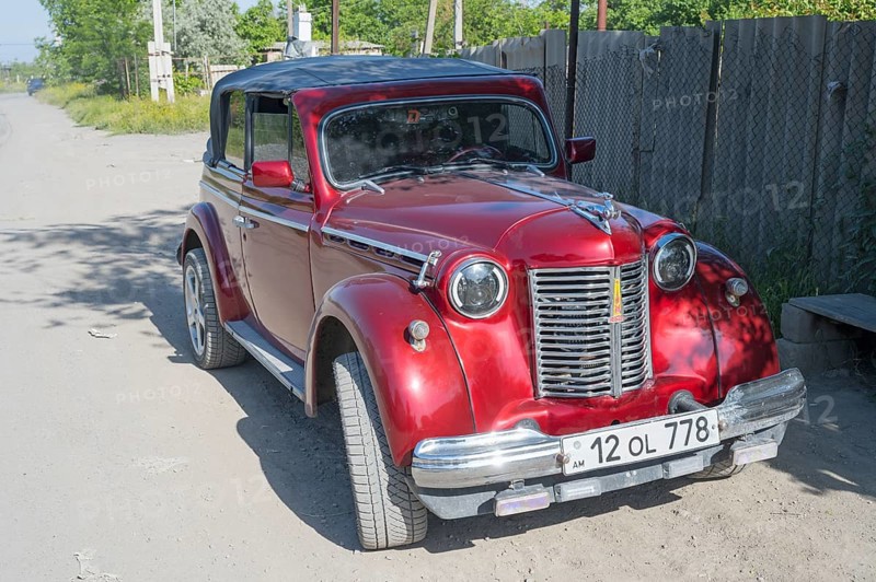 Red vintage car parked on a dusty road in the sunshine, Moskvich 401, Armavir province, Armenia