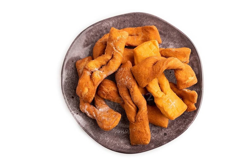 Crunchy biscuit Brushwood cookies sprinkled with powdered sugar isolated on white background, top view, flat lay, close up