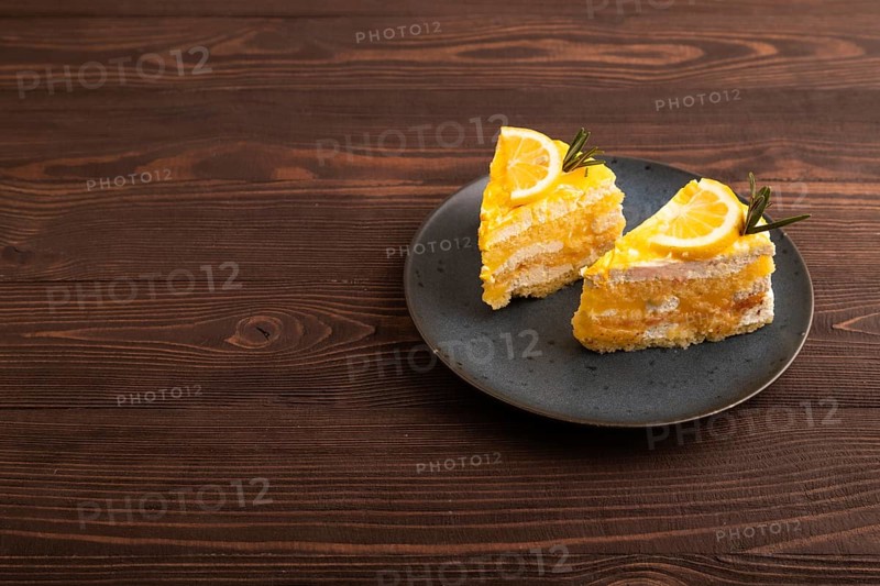 Lemon cake on brown wooden background, side view, copy space