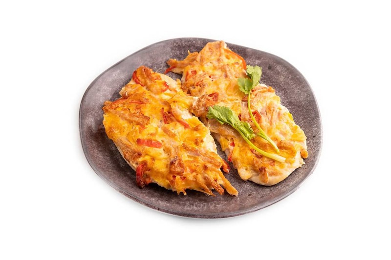 Baked chicken meat with cheese and tomatoes isolated on white background. side view, close up