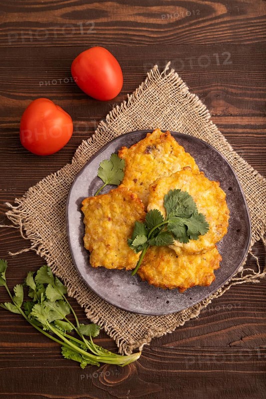 Fried crispy Chicken pancakes on brown wooden background and linen textile. top view, flat lay, close up