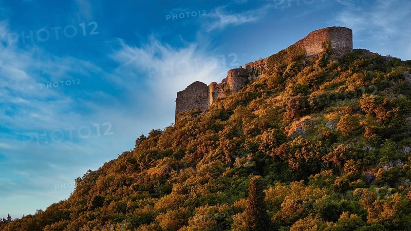 Byzantine castle from the 13th century AD, Ancient walls towering over a green, overgrown slope under a clear sky, Mystras, Mistra, UNESCO World Heritage Site, Medieval Byzantine ruined city, northwest of Sparta, foothills of the Tyagetos Mountains, Peloponnese, peninsula, Greece