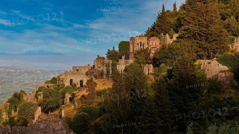 Church of Agia Sophia from the 14th century AD, ruins and trees cover a sunny hillside with a clear blue sky in the background, Mystras, Mistra, UNESCO World Heritage Site, Medieval Byzantine ruined city, northwest of Sparta, foothills of the Tyagetos Mountains, Peloponnese, peninsula, Greece