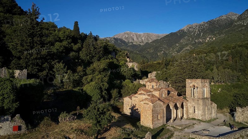 Drone shot, Church of Agia Sophia from the 14th century AD, Historic church and ruins surrounded by forest in mountainous landscape, Mystras, Mistra, UNESCO World Heritage Site, Medieval Byzantine ruined city, northwest of Sparta, foothills of the Tyagetos Mountains, Peloponnese, peninsula, Greece