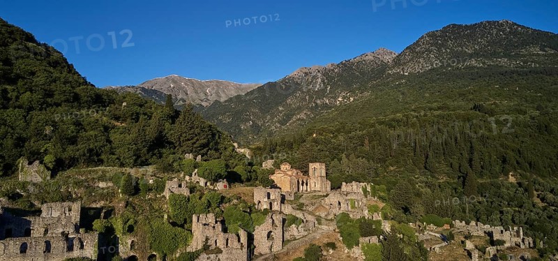 Drone shot, Ancient ruins in a mountainous and wooded environment in sunny weather, including the church of Agia Sophia from the 14th century AD, Mystras, Mistra, UNESCO World Heritage Site, Medieval Byzantine ruined city, northwest of Sparta, foothills of the Tyagetos Mountains, Peloponnese, Peninsula, Greece