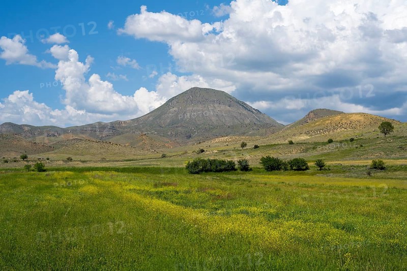 Mountain landscape with vast green and yellow fields under a cloudy sky, landscape near Shaghap, Ararat province, Armenia