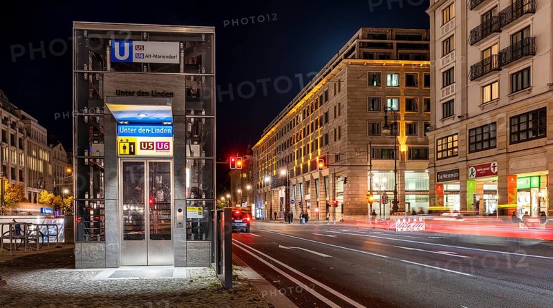 Night photo, long exposure with motion blur, modern lift at Unter den Linden underground station, contemporary design with bright lighting, U5 and U6 lines, Berlin, Germany
